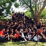 Participants gathered for a group photo on a lush green field