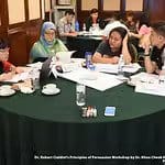 Several participants engaged in discussions and activities while seated around a table at the event
