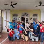 Members of Elite Indigo and participants posing together for a group photo at the entrance